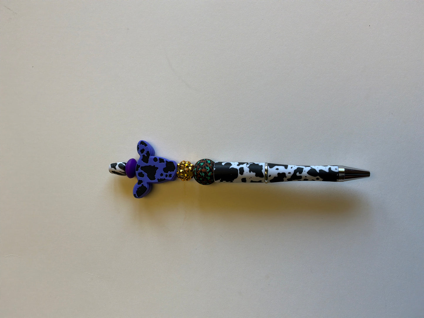 Beaded purple cow head on a black and white cow hide pen