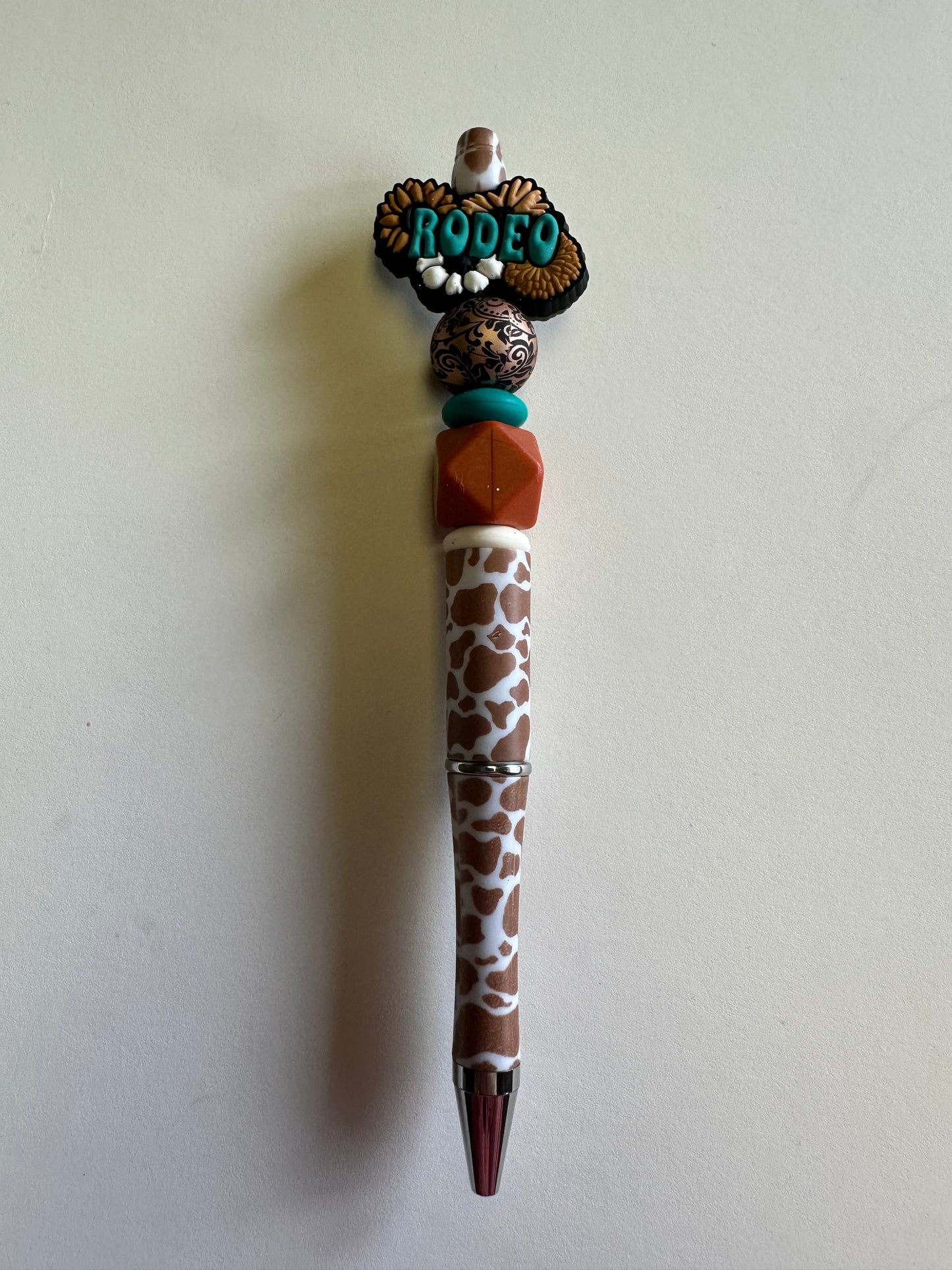 Beaded Rodeo with brown and white cow print pen